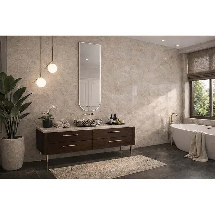 Cordia Rahmenspiegel - 50 x 140 cm, Gold, Aluminium - Badezimmerwand mit hellbeigen, gemusterten Fliesen in Natursteinoptik.
