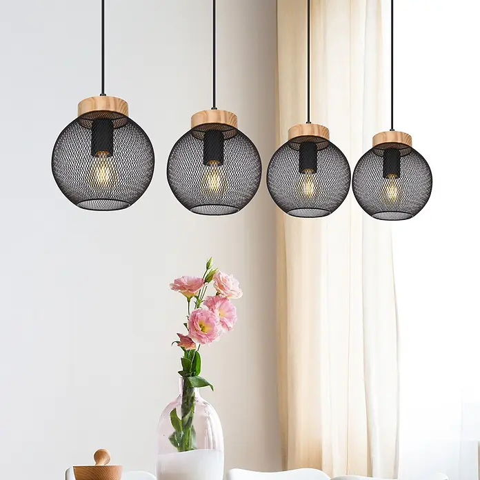 Globo Pendelleuchte Pablo - 40 W, L x B x H: 950 x 200 x 1.200 mm, E27 - Vier schwarze Gitterpendelleuchten mit Holzakzenten und leuchtenden Glühbirnen, hängen über einem Tisch mit Blumen.