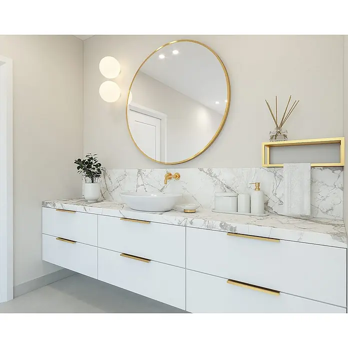 Cordia Rahmenspiegel - 80 x 80 cm, Gold, Aluminium - Moderne Badezimmermöbel mit weißer Marmorplatte, weißen Schubladen, goldenen Griffen, Aufsatzwaschbecken und goldener Armatur in einem hellen Bad.