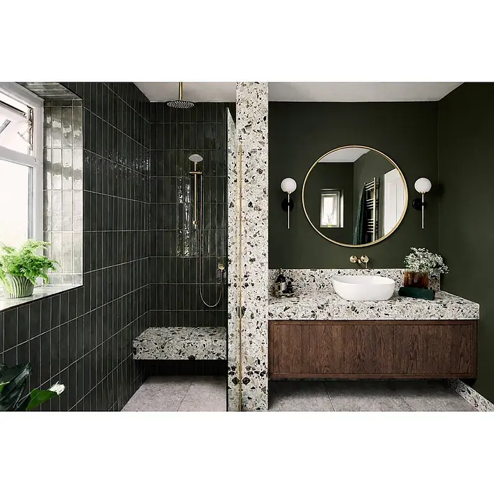 Cordia Rahmenspiegel - 80 x 80 cm, Gold, Aluminium - Modernes Badezimmer mit dunkelgrünen Fliesen und Wänden, Terrazzo-Waschtisch und Duschbank, weißem Waschbecken und Goldarmaturen.
