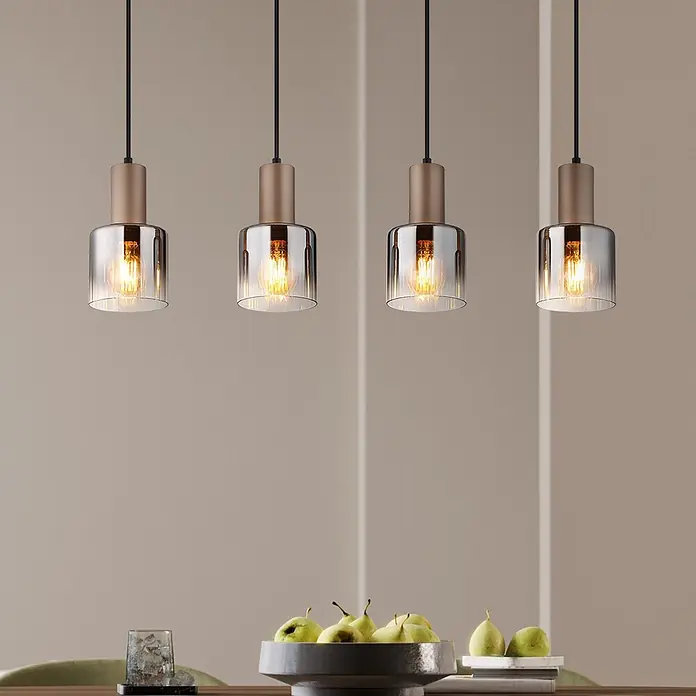Globo Pendelleuchte Walton - 40 W, L x B x H: 780 x 120 x 1.500 mm, E27 - Vier moderne Pendelleuchten mit kupferfarbenen Oberteilen und klaren Glasschirmen, reihenweise über einem Tisch hängend, für warme Beleuchtung.