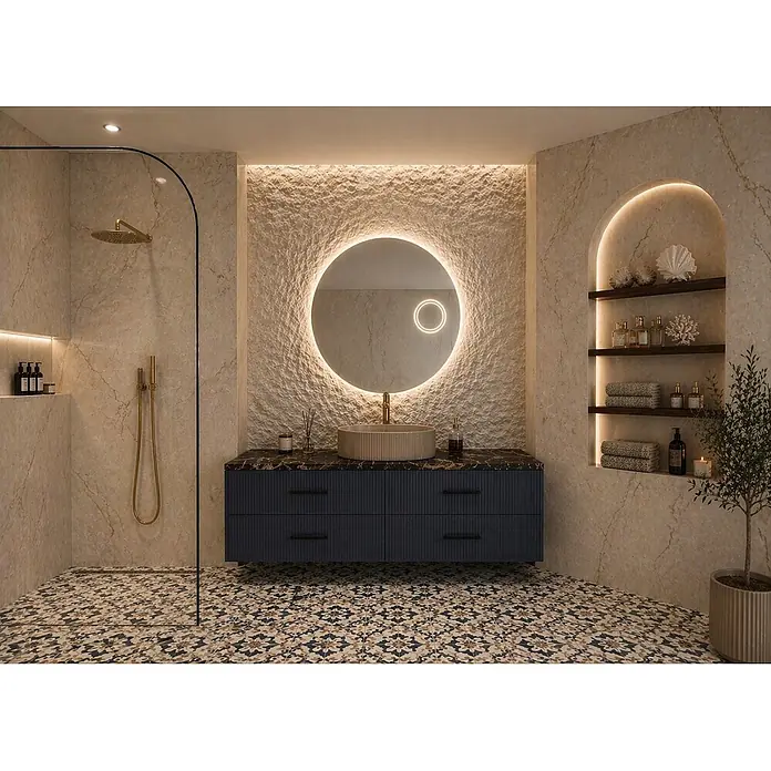 Cordia Lichtspiegel - 80 x 80 cm, Silber - Modernes Badezimmer mit gemusterten Bodenfliesen, strukturierter Wand, hinterleuchtetem Rundspiegel, dunkelblauem Waschtisch und Dusche mit Goldarmaturen.