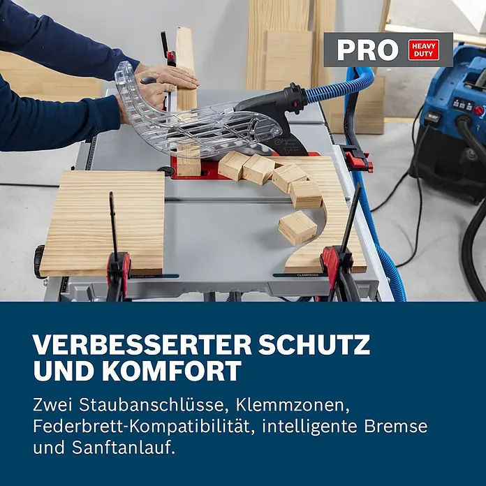 Bosch Professional Tischkreissäge GTS100-254 - 2.200 W, Durchmesser Sägeblatt: 254 mm, Schnitttiefe bei 90 °: 100 mm - Person schneidet Holz auf einer grauen Tischkreissäge mit klarem Schutz und blauem Absaugschlauch. PRO HEAVY DUTY Werkzeug mit verbessertem Schutz und Komfort.