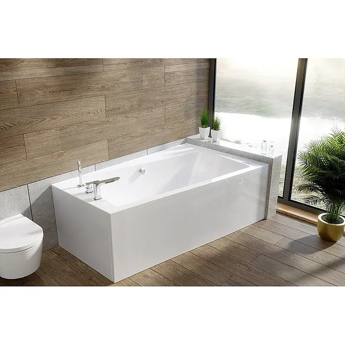 Bad Land Eckbadewanne INFINITY Acryl-Eckwanne 170 x 110 cm rechts Weiß - Sanitäracryl, Weiß - Weiße rechteckige Badewanne mit Chromarmaturen in einem modernen Badezimmer vor einem großen Fenster.