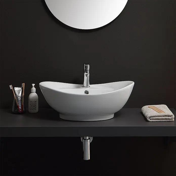 Kiamami Valentina Aufsatzwaschbecken - 39 x 59 cm, Weiß - Weißes Keramik-Aufsatzwaschbecken mit Chromarmatur, elegant geformt auf dunkler Arbeitsplatte.