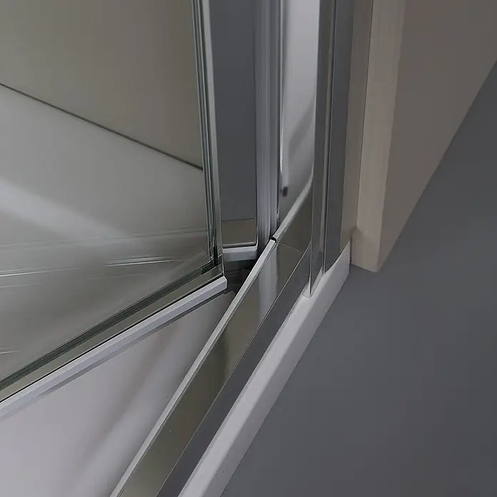 Kiamami Valentina Nischendusche - 0,02 x 1.900 cm, Transparent, 5 mm - Nahaufnahme des unteren Chromprofils einer Duschkabine mit Glaswand und weißer Dichtung.