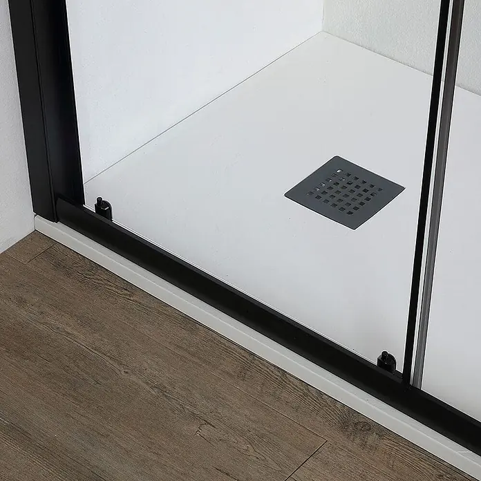 Kiamami Valentina Nischendusche - 50 x 1.900 cm, Schwarz, 6 mm - Weiße Duschwanne mit dunklem quadratischem Abfluss und schwarzem Duschrahmen neben Holzfußboden.