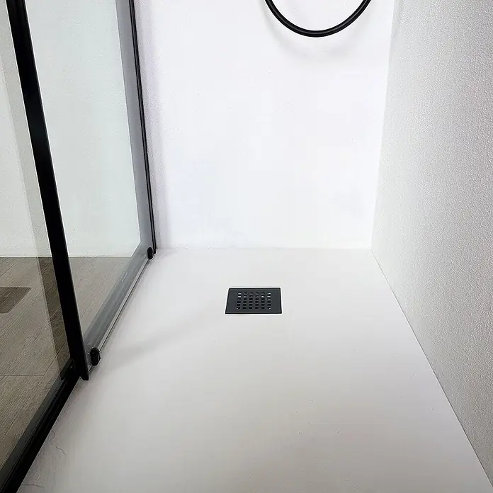 Kiamami Valentina Nischendusche - 50 x 1.900 cm, Schwarz, 6 mm - Quadratischer schwarzer Duschablauf auf einer weißen Duschwanne.
