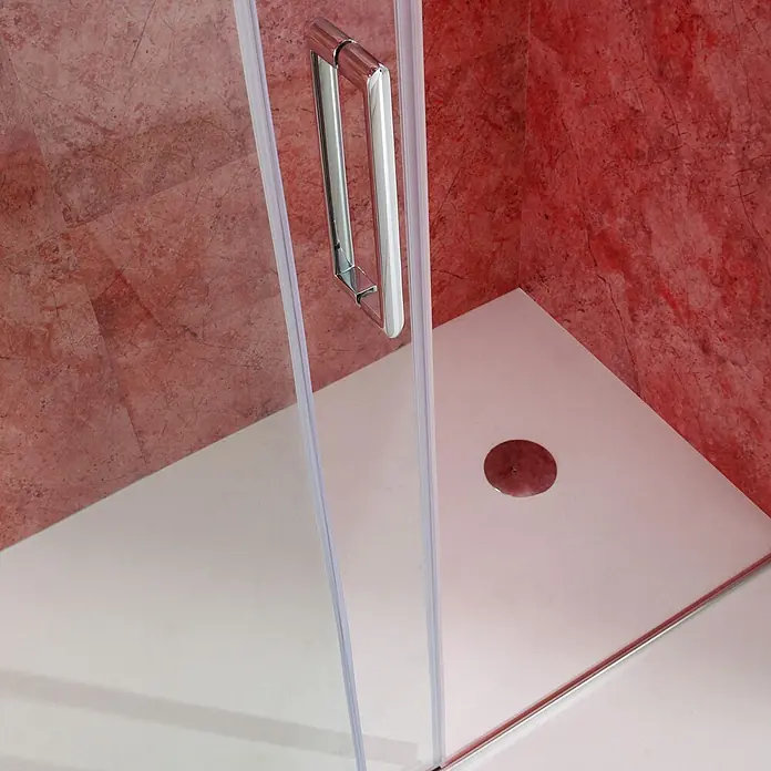 Kiamami Valentina Nischendusche - Transparent, 6 mm - Chromgriff an Glastür einer Dusche mit weißer Duschwanne vor roter Marmorwand.