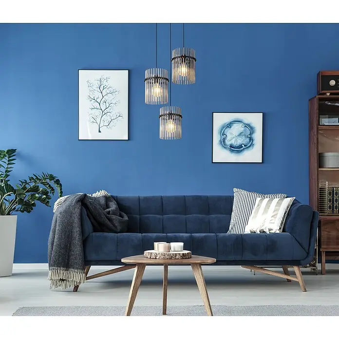 Globo Pendelleuchte Gorley - L x B x H: 800 x 200 x 1.400 mm - Blaues Samtsofa mit gesteppten Kissen und Holzbeinen in einem modernen Wohnzimmer.