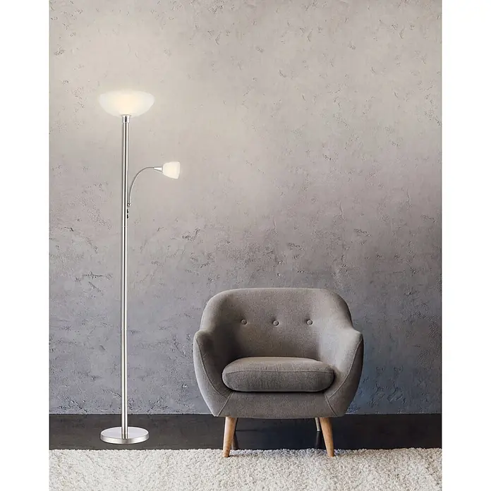 Globo LED-Stehleuchte Blade - 8,8 W, Silber, Warmweiß, Ø x H: 30 x 178 cm - Eine silberne Stehleuchte mit Deckenfluter und verstellbarer Leselampe beleuchtet einen gemütlichen grauen Sessel.