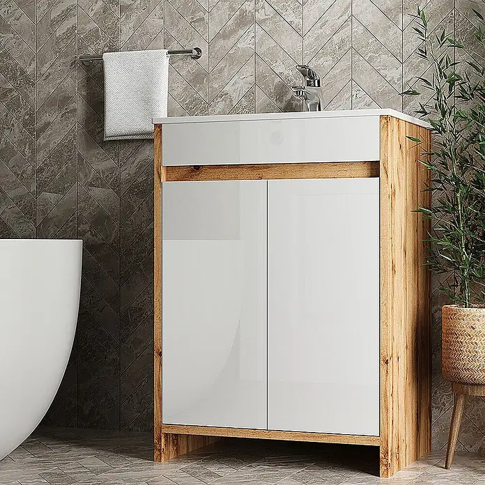 Vicco Badmöbel-Set Lemgo Goldkraft Eiche 2 Teile - Goldkraft Eiche, Glänzend - Weißer Hochglanz-Badunterschrank mit hellem Holzdekorrahmen und Chromarmatur, in einem modern gefliesten Bad.