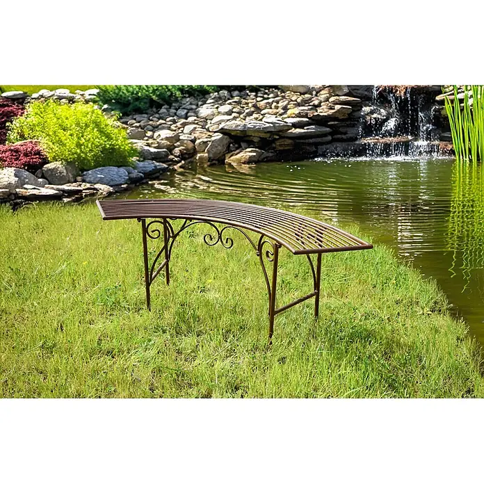 Garden Pleasure Gartenbank Fuego - B x T x H: 125 x 28 x 47 cm, Eisen, Braun - Gebogene braune Metall-Gartenbank in einer grünen Gartenlandschaft am Teich.