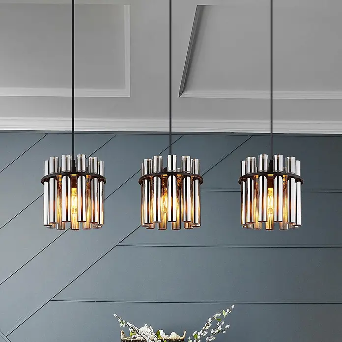 Globo Pendelleuchte Gorley - 60 W, Ø x H: 20 x 120 cm - Drei industrielle Pendelleuchten mit zylindrischen Metall- und Bernstein-Glasrohren beleuchten einen modernen Raum.