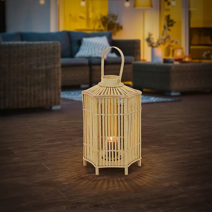 ECD Germany Windlicht Boho Bambus Laterne - Ø x H: 30 x 60 cm, Natur - Natürliche Bambuslaterne mit brennender Kerze, wirft Schatten auf dunklen Holzboden in abendlicher Außenumgebung.