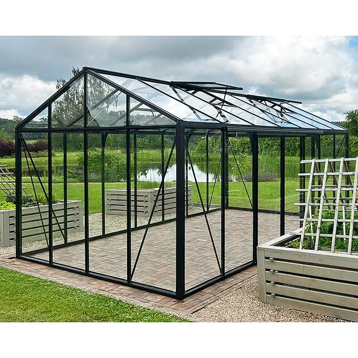 Bloomcabin Gewächshaus Aluminium Klassik - Außenmaß inkl. Dachüberstand (B x T): 309 x 533 cm, Material Seitenwand: Glas, 4 mm, Schwarz - Großes Gewächshaus mit schwarzem Rahmen und Glaswänden, offenen Dachfenstern, auf einer gepflasterten Terrasse im Garten mit Hochbeeten.