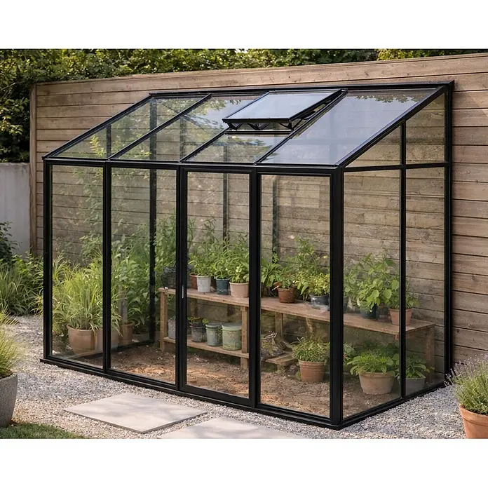 Bloomcabin Gewächshaus Aluminium Wandgewächshaus - Außenmaß inkl. Dachüberstand (B x T): 309 x 160 cm, Höhe: 251 cm, Material Seitenwand: Glas, 4 mm, Schwarz - Schwarz gerahmtes Glasgewächshaus mit Topfpflanzen in einem Garten.