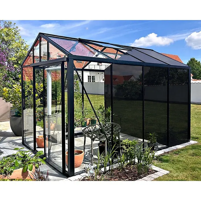 Bloomcabin Gewächshaus Aluminium Klassik mit kleinem integrierten Stauraum - Außenmaß inkl. Dachüberstand (B x T): 235 x 309 cm, Material Seitenwand: Glas, 4 mm, Schwarz - Modernes Gewächshaus mit schwarzem Rahmen, klaren und dunklen Glaspaneelen im Garten.