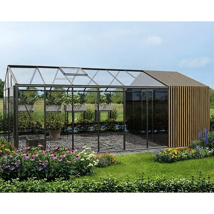 Bloomcabin Gewächshaus Aluminium Klassik mit Accoya-Fusion und mittlerem integrierten Stauraum - Außenmaß inkl. Dachüberstand (B x T): 309 x 608 cm, Material Seitenwand: Glas, 4 mm, Schwarz - Modernes Gewächshaus mit dunkel gerahmten Glaspaneelen und einer Holzlamellenseite, in einem blühenden Garten.