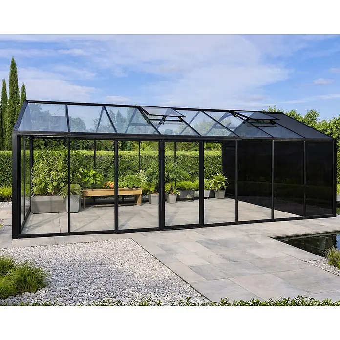 Bloomcabin Gewächshaus Aluminium Klassik mit kleinem integrierten Stauraum - Außenmaß inkl. Dachüberstand (B x T): 235 x 608 cm, Material Seitenwand: Glas, 4 mm, Schwarz - Modernes, schwarz gerahmtes Glasgewächshaus mit transparenten Paneelen und einem schwarzen, undurchsichtigen Bereich, ideal für den Gartenanbau.