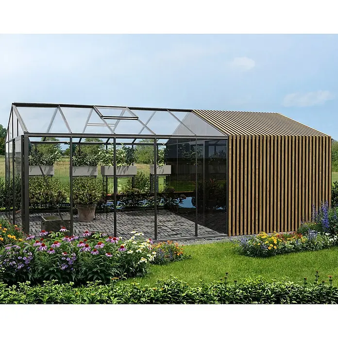 Bloomcabin Gewächshaus Aluminium Klassik mit Accoya-Fusion und großem integrierten Stauraum - Außenmaß inkl. Dachüberstand (B x T): 309 x 608 cm, Material Seitenwand: Glas, 4 mm, Schwarz - Modernes Gewächshaus mit schwarzem Rahmen, Glas und einer Holzlamellenwand, umgeben von einem üppigen Garten.