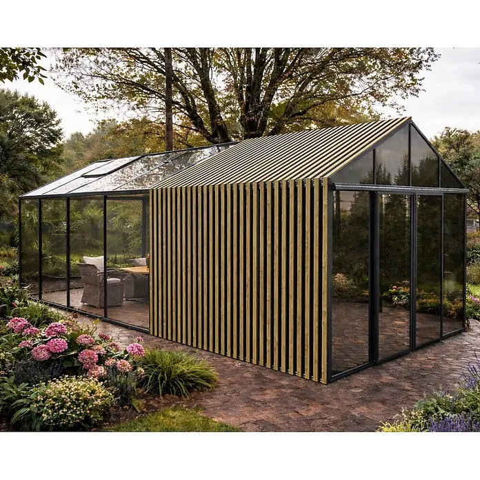 Bloomcabin Gewächshaus Aluminium Klassik mit Accoya-Fusion und großem integrierten Stauraum - Außenmaß inkl. Dachüberstand (B x T): 309 x 533 cm, Material Seitenwand: Glas, 4 mm, Schwarz - Moderner Glas-Gartenraum mit schwarzem Rahmen und vertikaler Holzlamellenverkleidung an einer Seite und am Dach, umgeben von einem Garten.