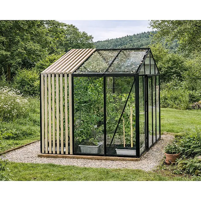 Bloomcabin Gewächshaus Aluminium Limited Edition mit Accoya-Fusion - Außenmaß inkl. Dachüberstand (B x T): 309 x 235 cm, Material Seitenwand: Glas, 4 mm, Schwarz - Modernes Gewächshaus mit schwarzem Rahmen, Glaswänden und Holzlatten, mit Pflanzen.