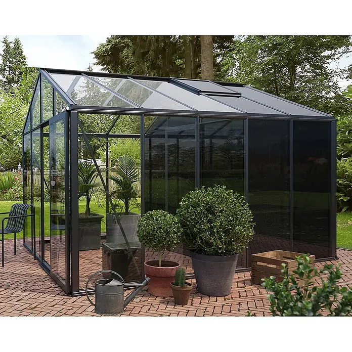 Bloomcabin Gewächshaus Aluminium Klassik mit mittlerem integrierten Stauraum - Außenmaß inkl. Dachüberstand (B x T): 309 x 384 cm, Material Seitenwand: Glas, 4 mm, Schwarz - Modernes Gewächshaus mit dunklem Rahmen und klaren sowie getönten Glaspaneelen, auf einer Backsteinterrasse im Garten.