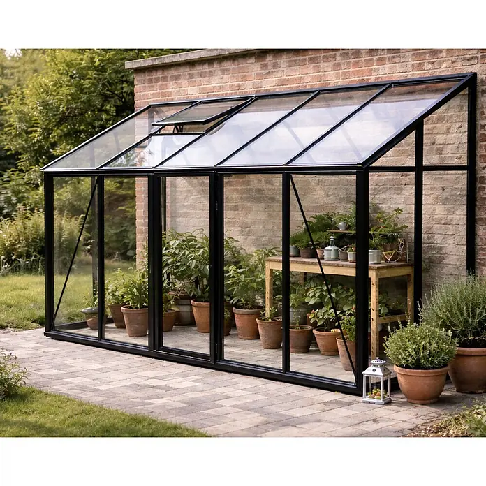Bloomcabin Gewächshaus Aluminium Wandgewächshaus - Außenmaß inkl. Dachüberstand (B x T): 384 x 160 cm, Höhe: 251 cm, Material Seitenwand: Glas, 4 mm, Schwarz - Schwarz gerahmtes Anlehngewächshaus mit Glaspaneelen an einer Ziegelmauer, mit offenem Dachfenster und Topfpflanzen.