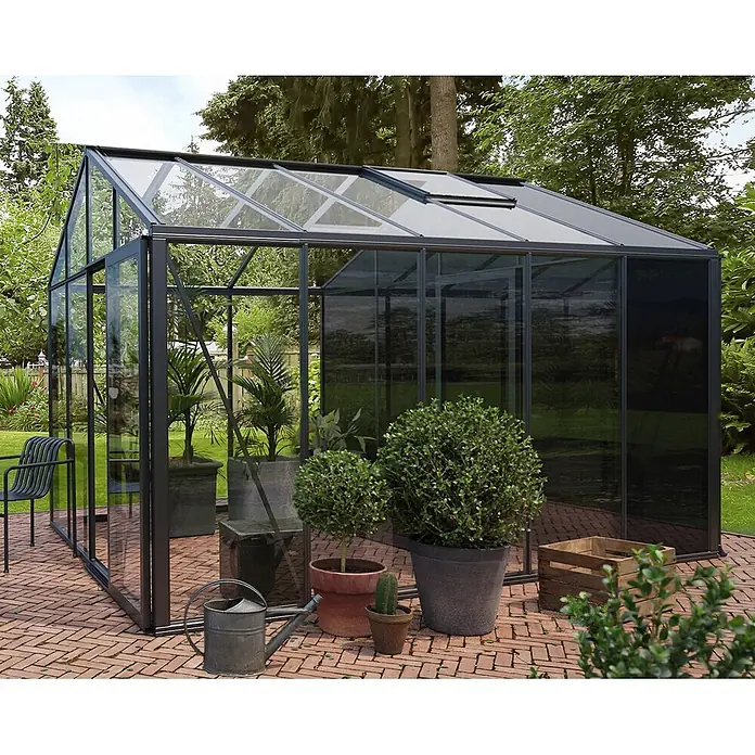 Bloomcabin Gewächshaus Aluminium Klassik mit kleinem integrierten Stauraum - Außenmaß inkl. Dachüberstand (B x T): 309 x 384 cm, Material Seitenwand: Glas, 4 mm, Schwarz - Ein modernes Gewächshaus mit schwarzem Rahmen und Glaspaneelen, teils getönt, auf einer Ziegelterrasse im Garten zum Pflanzenanbau.