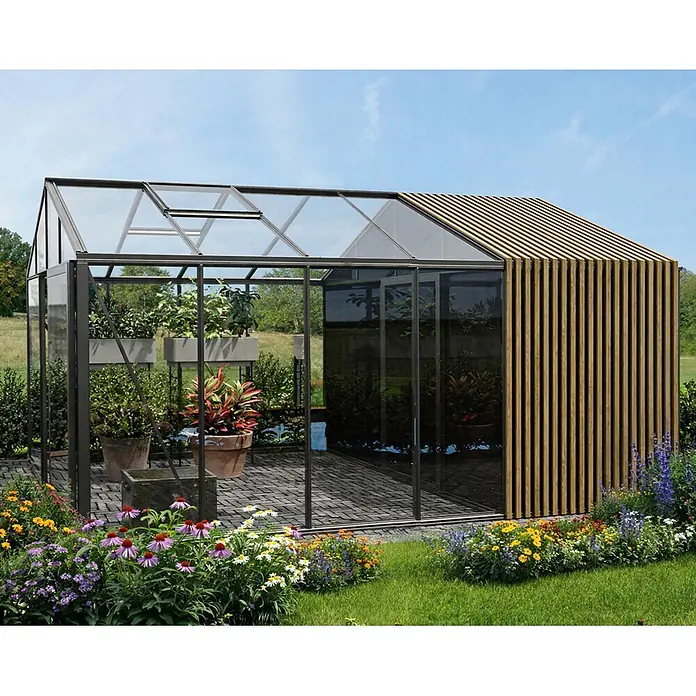 Bloomcabin Gewächshaus Aluminium Klassik mit Accoya-Fusion und mittlerem integrierten Stauraum - Außenmaß inkl. Dachüberstand (B x T): 235 x 533 cm, Material Seitenwand: Glas, 4 mm, Schwarz - Modernes Gewächshaus mit schwarzem Rahmen, Glaswänden und Holzlamellen, mit Pflanzen auf einer gepflasterten Terrasse im Garten.