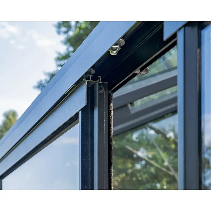 Bloomcabin Gewächshaus Aluminium Wandgewächshaus - Außenmaß inkl. Dachüberstand (B x T): 309 x 160 cm, Höhe: 251 cm, Material Seitenwand: Glas, 4 mm, Schwarz - Nahaufnahme eines schwarzen Metall-Gewächshausrahmens mit Glasscheiben und Schiebemechanismus.