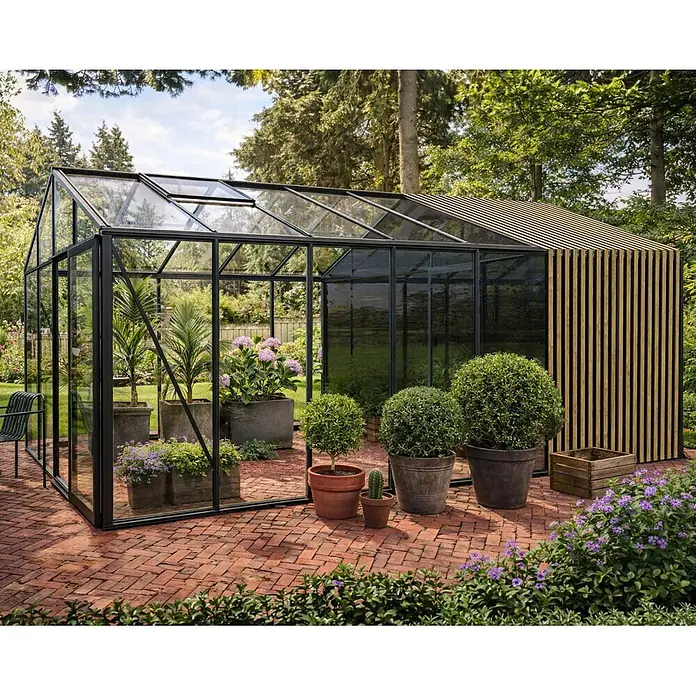 Bloomcabin Gewächshaus Aluminium Klassik mit Accoya-Fusion und mittlerem integrierten Stauraum - Außenmaß inkl. Dachüberstand (B x T): 309 x 533 cm, Material Seitenwand: Glas, 4 mm, Schwarz - Modernes Gewächshaus mit schwarzem Rahmen, Glas und Holzlamellen, mit Pflanzen auf einer Ziegelterrasse.