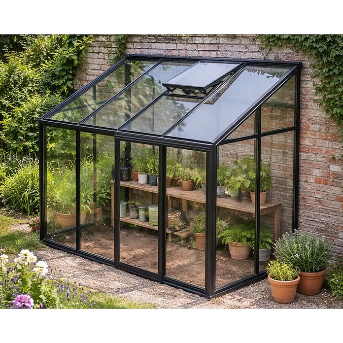 Bloomcabin Gewächshaus Aluminium Wandgewächshaus - Außenmaß inkl. Dachüberstand (B x T): 309 x 160 cm, Höhe: 268 cm, Material Seitenwand: Glas, 4 mm, Schwarz - Kleines schwarzes Anlehn-Gewächshaus mit Glaswänden und geöffnetem Dachfenster, gefüllt mit Topfpflanzen auf Holzregalen, vor einer Ziegelwand.