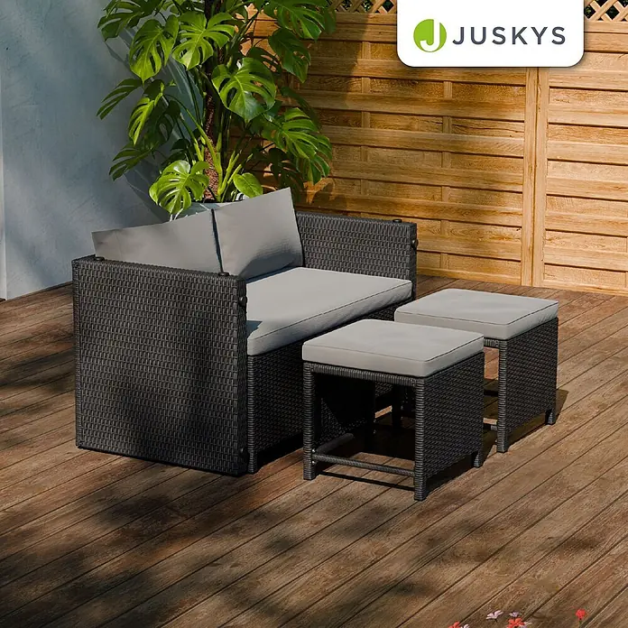 Juskys Loungemöbel-Set Jamaika - 4 -tlg., Geflecht / Gestell: Polyrattan / Stahl; Bezug: 180 g/m² Polyester; Tischplatte: Polywood, Schwarz - Dunkelgraue Rattan-Sitzgruppe für draußen mit hellgrauen Kissen, bestehend aus einem Sofa und zwei Hockern.