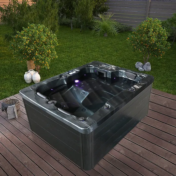 Home Deluxe Outdoor Whirlpool BLACK MARBLE Pure -  - Moderner dunkelgrauer Whirlpool mit lila Innenbeleuchtung, auf einer Holzterrasse.