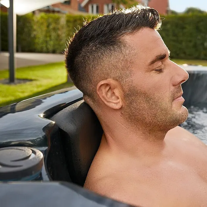 Home Deluxe Outdoor Whirlpool BLACK MARBLE Pure -  - Dunkle, ergonomische Whirlpool-Kopfstütze, die den Kopf eines Mannes beim Entspannen stützt.