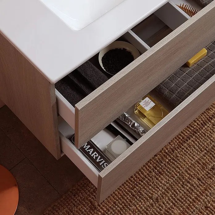 Kiamami Valentina Badmöbel-Set - Helles Holz - Badezimmermöbel in heller Holzoptik mit weißem Waschbecken und zwei offenen Schubladen für Toilettenartikel und Handtücher.