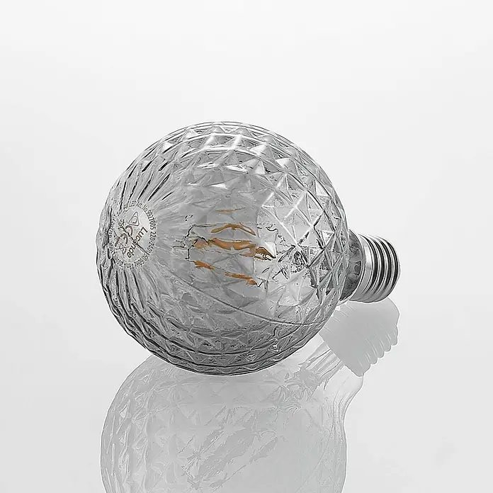 Lucande LED-Lampe E27 G95 LED 4W - E27, Nicht Dimmbar, Warmweiß, 150 lm, 4 W - Kugelförmige LED-Glühbirne mit facettierter, silberfarbener Glasoberfläche und metallischem Schraubsockel, auf der Seite liegend.