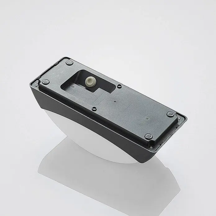 Lindby Außenwandleuchte Alexey - schwarz, schwarz, IP65 - Unterseite einer dunkelgrauen Wandleuchte mit weißem Diffusor, Montagepunkte und Sensor sichtbar.