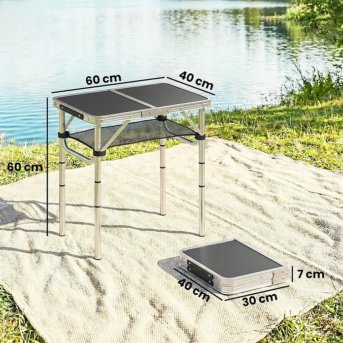 Outsunny Campingtisch - MDF (Mitteldichte Faserplatte), Schwarz - Silber-schwarzer klappbarer Campingtisch, offen (60x40x60 cm) und gefaltet (40x30x7 cm) am See auf einer Decke.