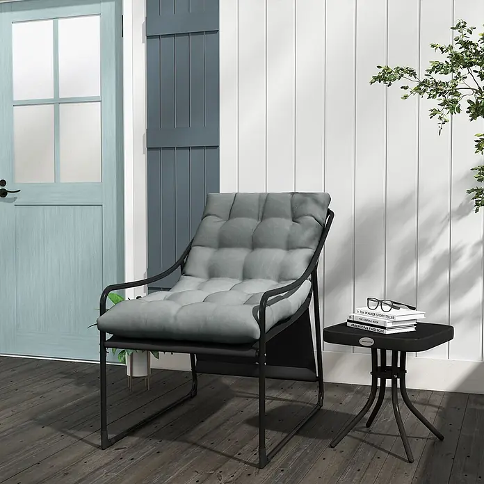 Outsunny Garten-Loungesessel - Stahl, Polyester, Grau - Outdoor-Loungeset mit schwarzem Metallstuhl, grauem Kissen und schwarzem Beistelltisch mit Büchern auf dunklem Holzdeck.