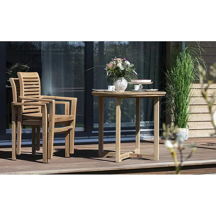 Gartenmöbelset Stapelsessel Derby & Tisch Retford -  - Teakholz-Gartenset mit zwei Stühlen und rundem Tisch auf Holzterrasse, gedeckt mit Blumen und Kuchen.