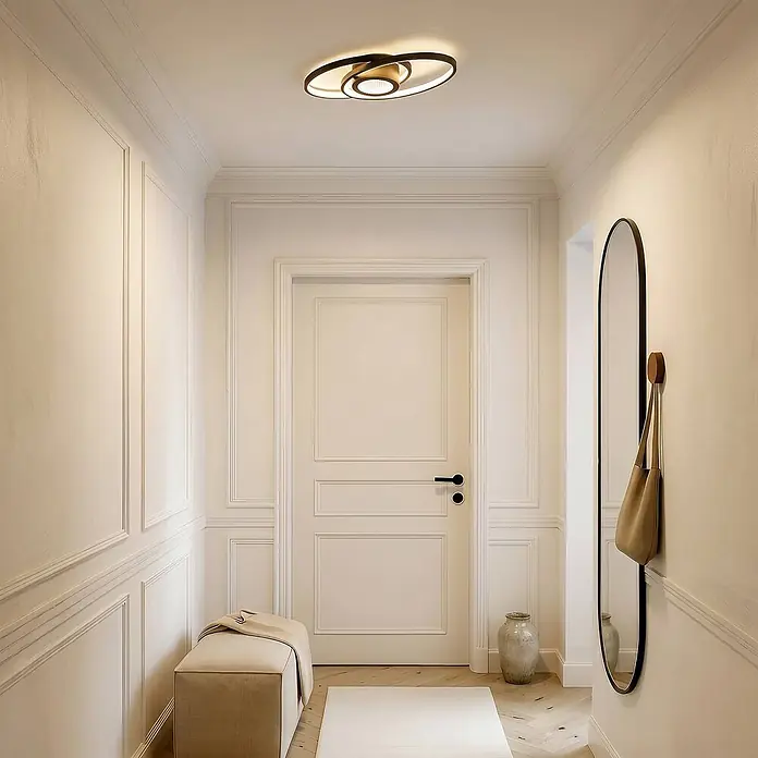 Lindby Deckenleuchte Thalina - schwarz, schwarz - Moderne schwarze und goldene ovale LED-Deckenleuchte erhellt einen Flur.