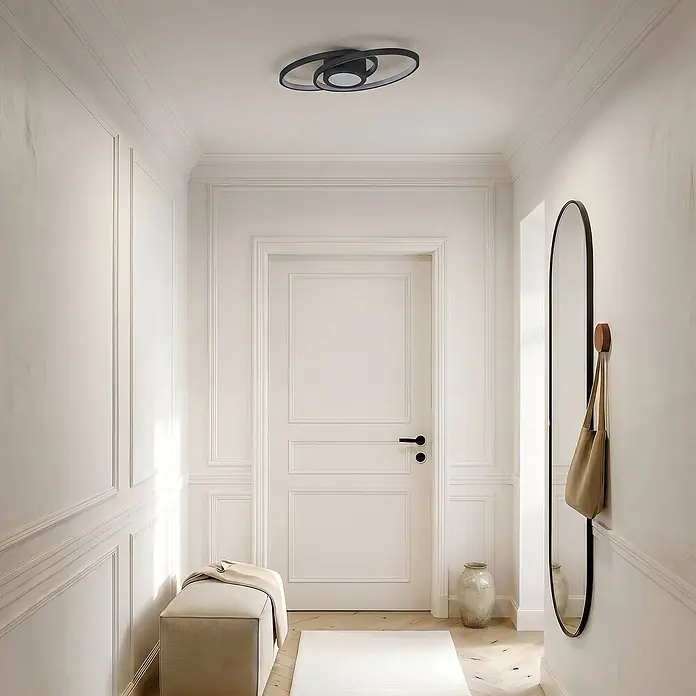Lindby Deckenleuchte Thalina - schwarz, schwarz - Eine moderne schwarze ovale Deckenleuchte beleuchtet einen hellen Flur.