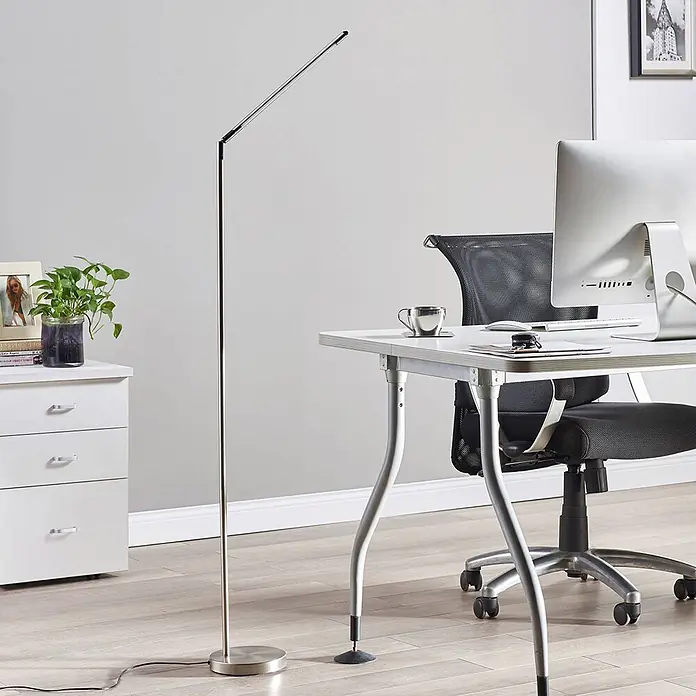 Lindby Stehleuchte Jabbo - alu / grau / zink, alu / grau / zink - Schlanke silberne Stehlampe in einem modernen Büro neben einem Schreibtisch.