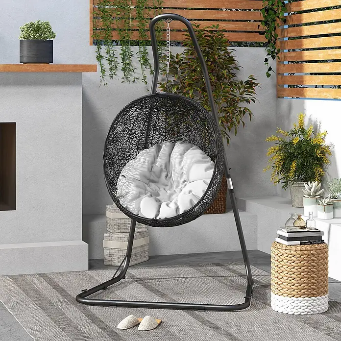 Outsunny Hängesesselgestell - L x B x H: 133 x 116 x 230 cm, Metall - Schwarzer Hängesessel aus Geflecht mit weißem Kissen, auf einer Terrasse platziert.