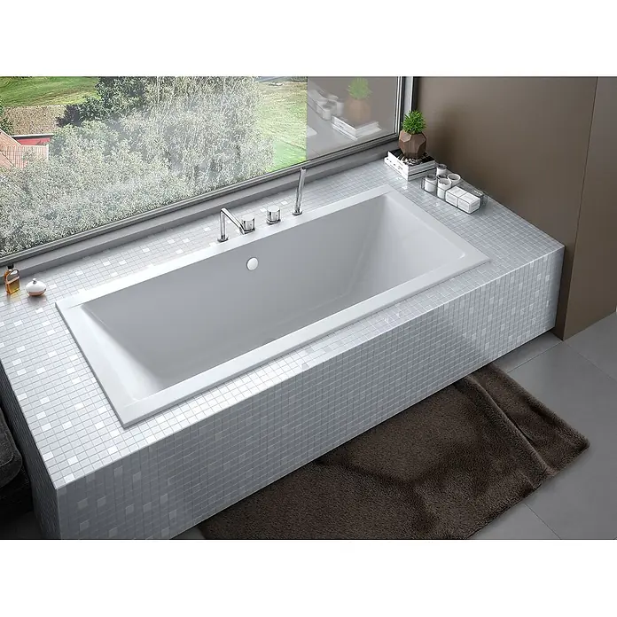 Bad Land Badewanne QUADRO SLIM Acryl-Eckwanne 170 x 75 cm Weiß - Sanitäracryl, Weiß - Weiße, rechteckige Einbau-Badewanne mit Chromarmaturen, in einer gefliesten Umrandung neben einem großen Fenster.