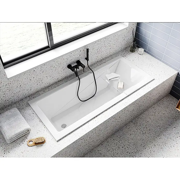 Bad Land Badewanne - 140 x 70 cm, Sanitäracryl, Weiß - Weiße Einbau-Badewanne mit schwarzen Armaturen, integriert in eine moderne gesprenkelte Terrazzo-Umrandung.