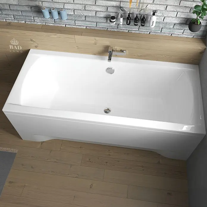 Bad Land Badewanne INES Acryl-Eckwanne 170 x 75 cm Weiß, inkl. Acrylschürze und Siphon - 170 x 75 cm, Sanitäracryl, Weiß - Weiße rechteckige Einbaubadewanne mit Chromarmatur und Abfluss, in einem modernen Badezimmer mit Holzverkleidung und Ziegelwand.